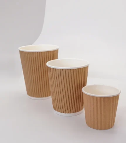 "Assorted sizes of ribbed brown coffee cups on a pristine white background, highlighting versatile packaging options from www.jcpackagingdubai.com."