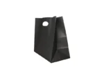 "A single black paper bag with a round die-cut handle hole, standing against a light background."