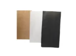 "Three paper bags in brown, white, and black colors lined up side by side."