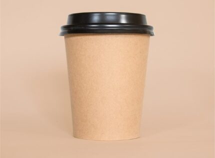 "Eco-friendly kraft paper coffee cup with a snug black lid, presented by JC Packaging Dubai."