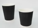 "Two premium black ripple paper cups designed for optimal insulation, offered by JC Packaging Dubai, showcasing sophisticated packaging solutions."