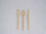 "A set of wooden cutlery including a fork, spoon, and knife on a white background, representing JC Packaging Dubai's eco-friendly packaging solutions at www.jcpackagingdubai.com."