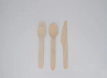 "A set of wooden cutlery including a fork, spoon, and knife on a white background, representing JC Packaging Dubai's eco-friendly packaging solutions at www.jcpackagingdubai.com."