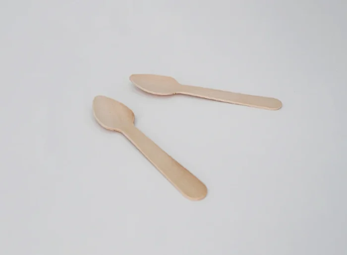 "Two handcrafted wooden spoons on a soft white background, reflecting the sustainable values of www.jcpackagingdubai.com."